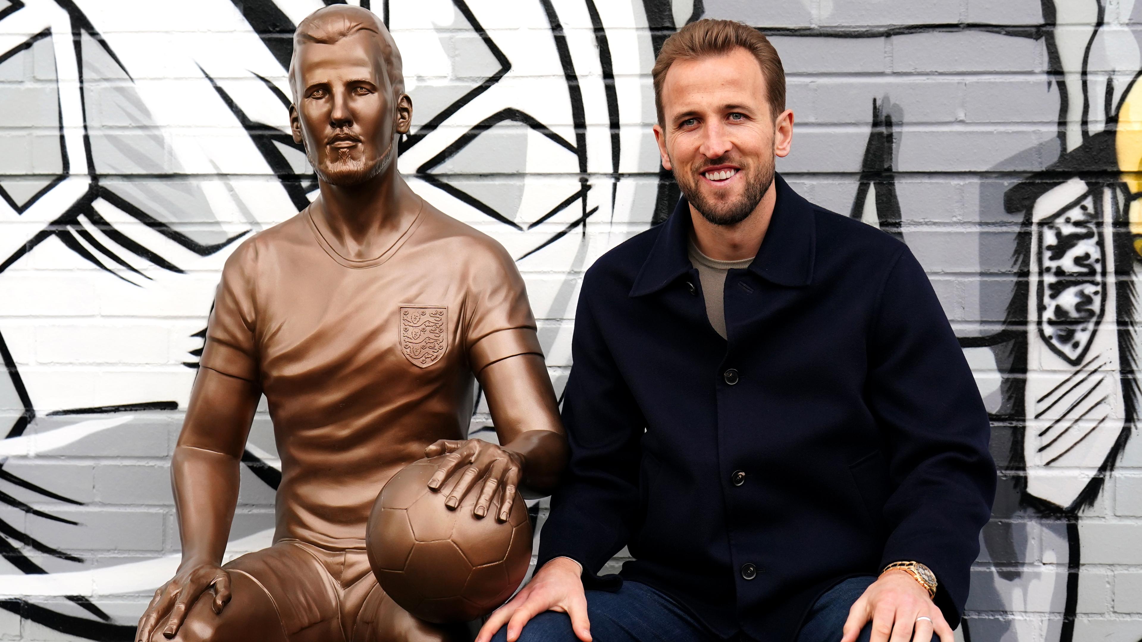 harry Kane sitzt neben Bronze-Statue