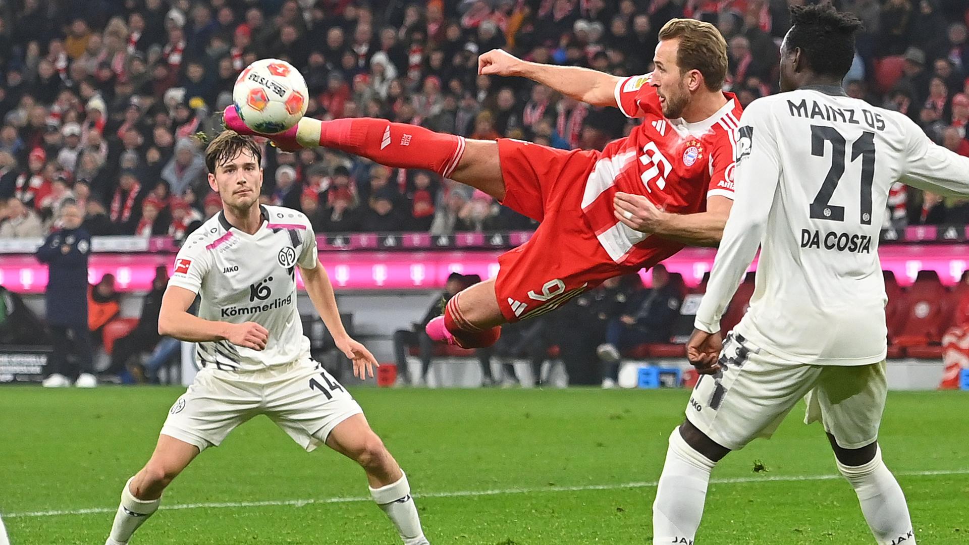 Bayerns Stürmer Harry Kane versucht mit einem Seitfallzieher im Mainzer 16er das Tor zu erzielen.