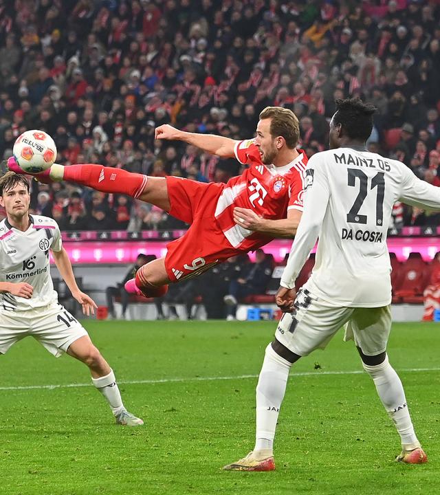 Bayerns Stürmer Harry Kane versucht mit einem Seitfallzieher im Mainzer 16er das Tor zu erzielen.