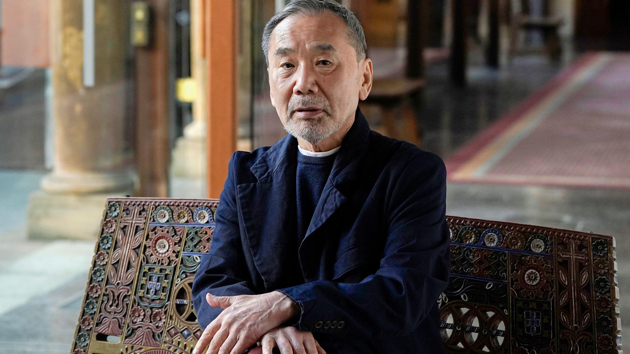 Ein Mann sitzt auf einem Stuhl und schaut in die Kamera