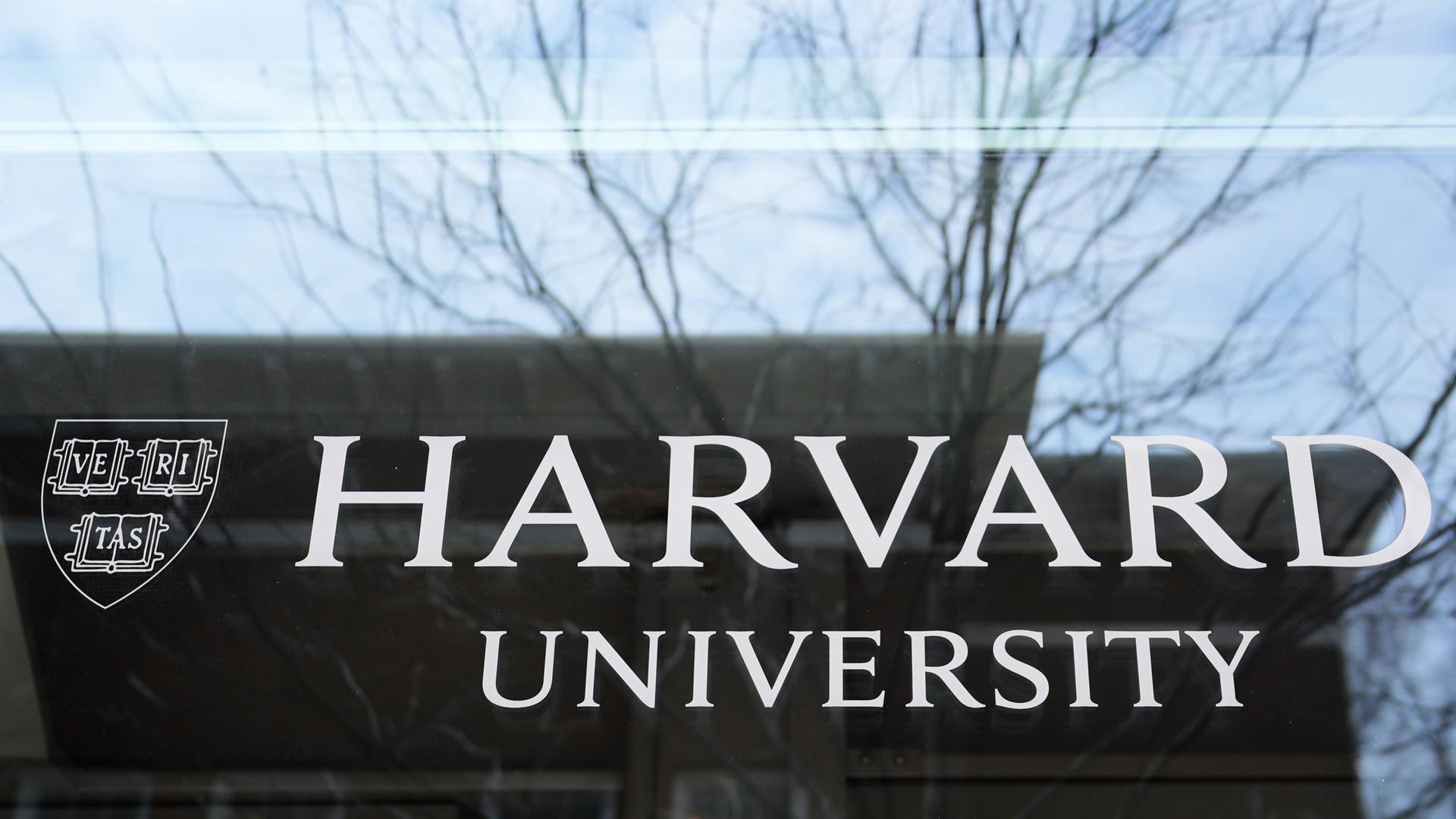 15.04.2025, USA, Cambridge: Das Logo der Harvard University prangt an einem Gebäude der Hochschule.