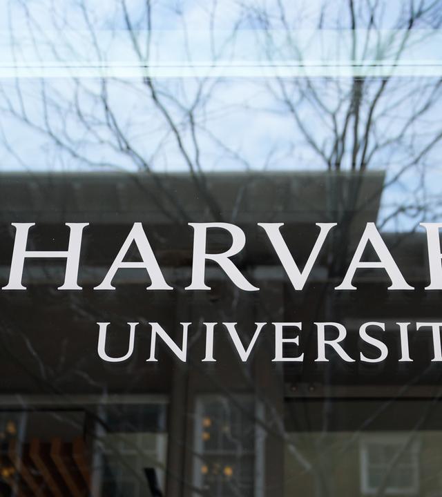 15.04.2025, USA, Cambridge: Das Logo der Harvard University prangt an einem Gebäude der Hochschule.
