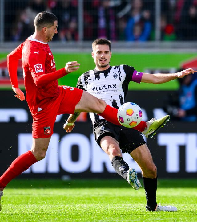 Gladbachs Julian Weigl (r) in Aktion gegen Heidenheims Norman Theuerkauf (l).