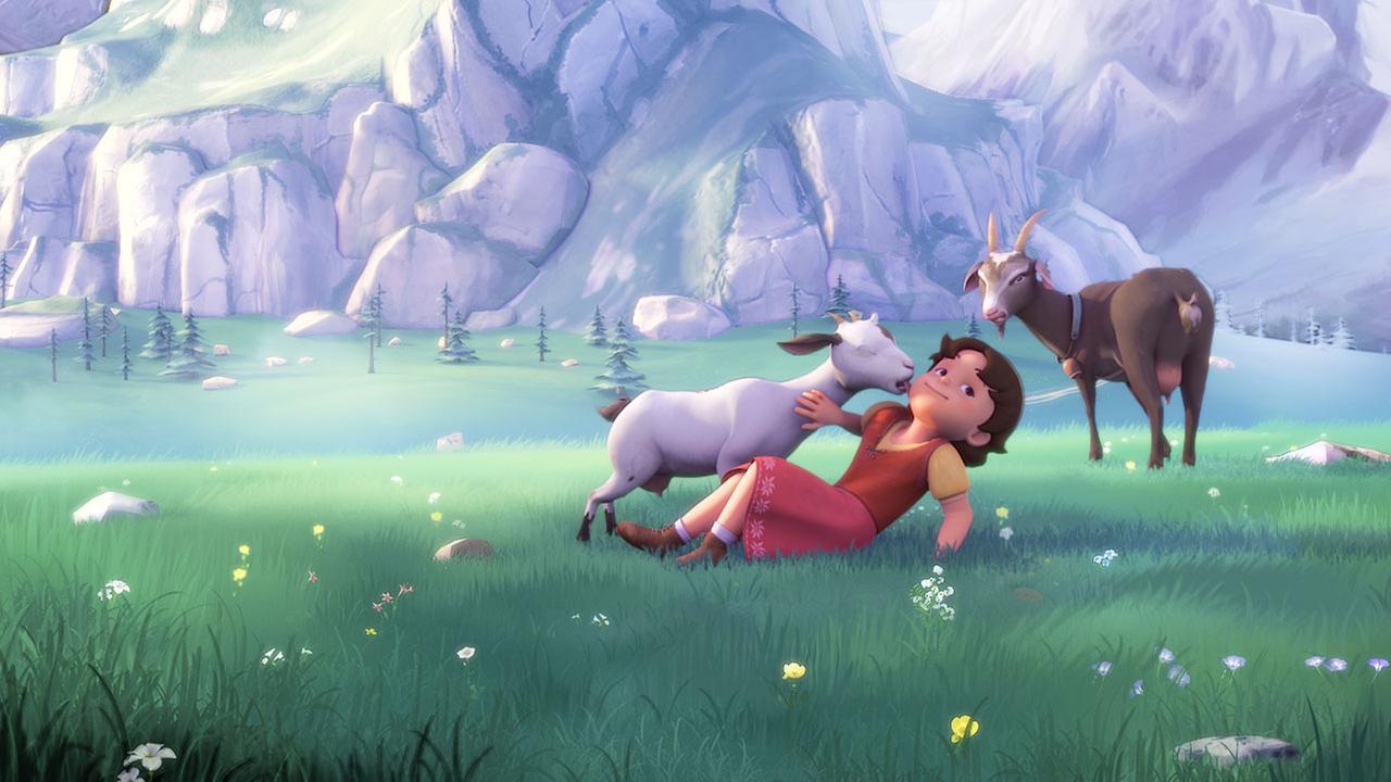 Heidi spielt auf einer Wiese mit Ziegen. Dabei schleckt ihr eine Ziege das Gesicht ab.