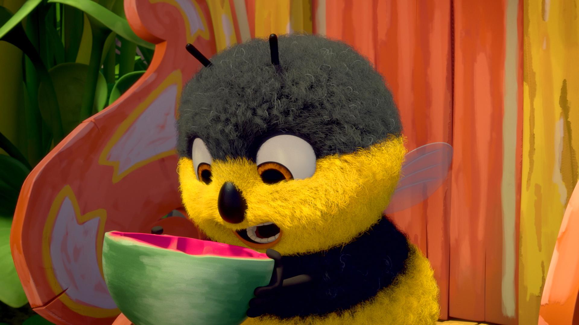 Hummel Heini beißt gierig in eine halbe Wassermelone hinein.
