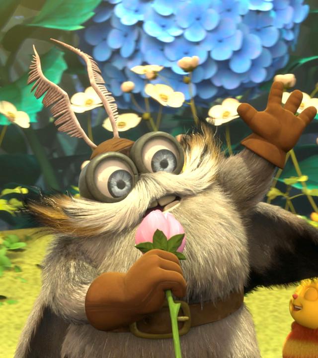 Senior Silbermotte (links) hält in der rechten Hand eine rosane Blüte, die er als Mikrofon benutzt. Die linke Hand streckt er in die Luft. Rechts neben ihm stehen drei kleine Bienenkinder und hören seiner Geschichte zu.