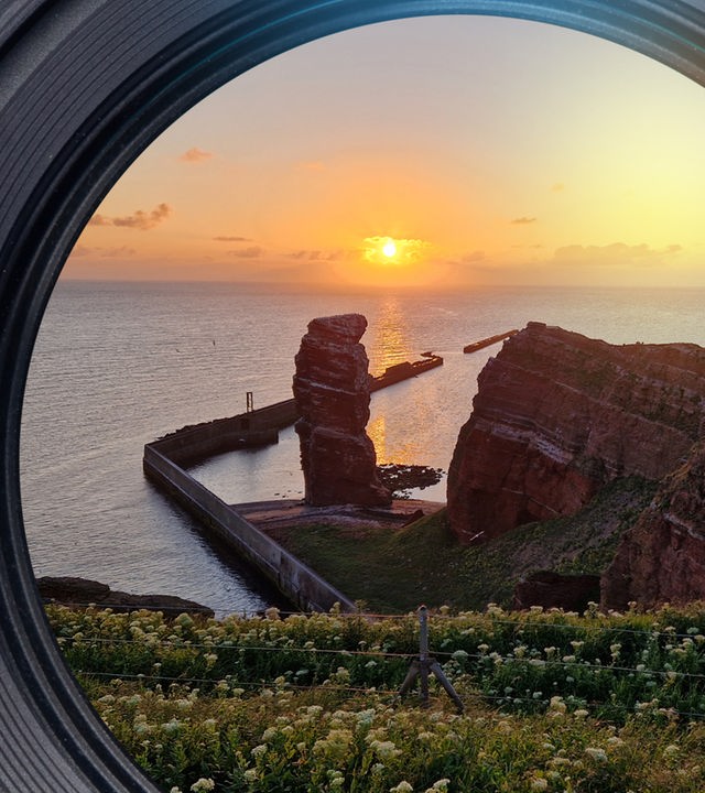 Panoramaaufnahme: Der Felsen 'Lange Anna' liegt auf Hegoland in der untergehenden Abendsonne.