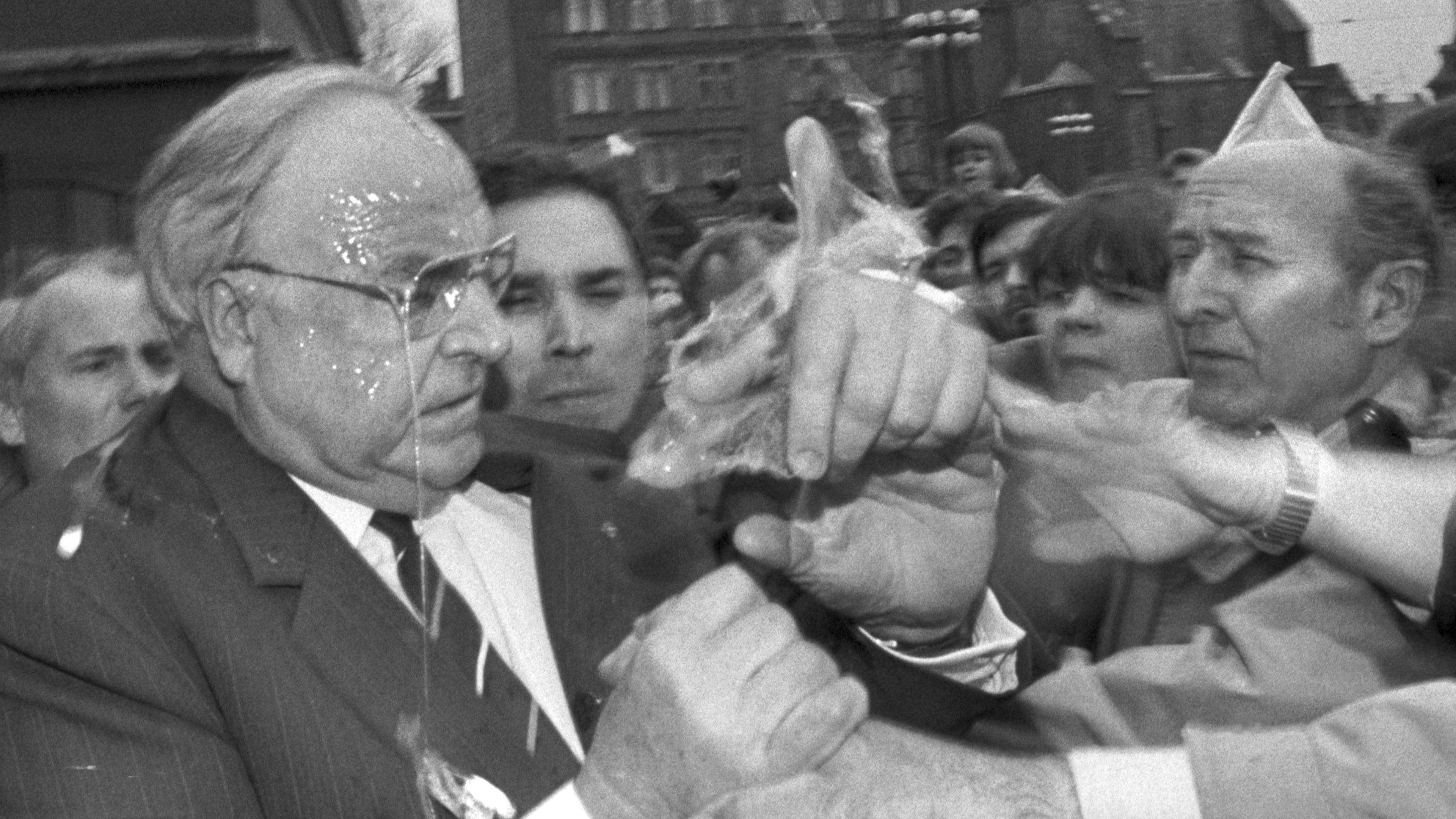 Das Eiweiß tropft Bundeskanzler Helmut Kohl in Halle von der Brille, während er versucht, den Eierwerfer in der ihm ansonsten zujubelnden Menge ausfindig zu machen (Archivfoto vom 10.05.1991).