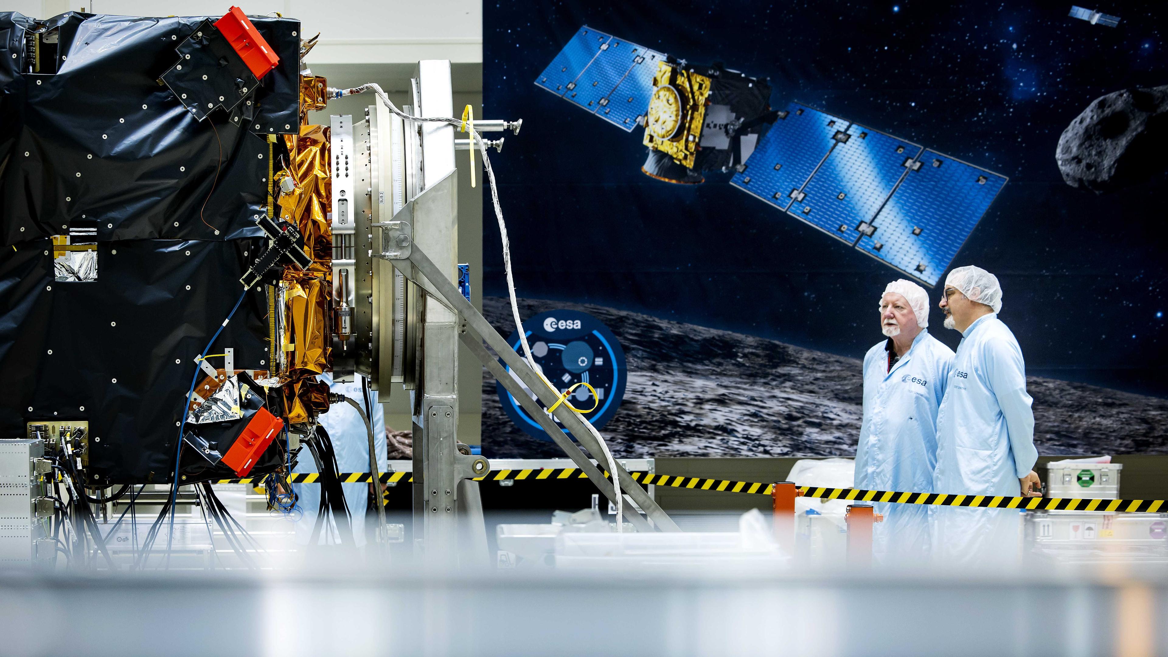 Wissenschaftler stehen neben der Raumsonde Hera im des Europäischen Weltraumforschungs- und Technologiezentrums.