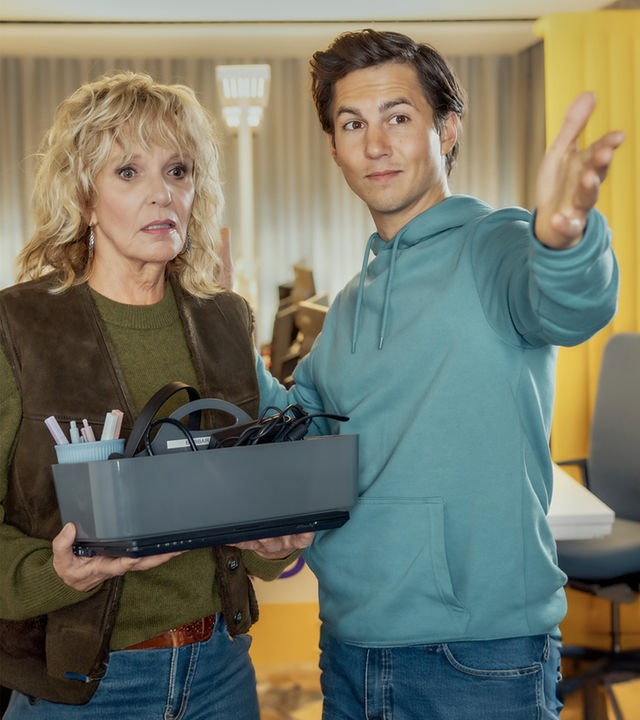 "Alle nicht ganz dicht": Barbara Lucke (Ulrike Kriener) steht neben ihrem Sohn Bastian (Tim Oliver Schultz) im Büro und hält Büromaterial in den Händen. Sie schaut mit unzufriedenem Blick in die Richtung, in die er zeigt.