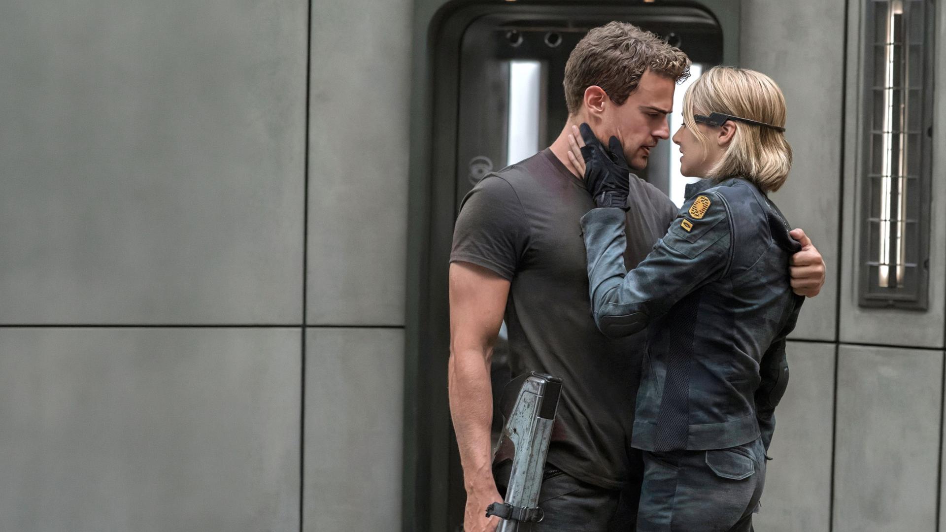 Beatrice Prior und Tobias Eaton stehen in einer Zelle, ihre Gesichter sind sich sehr nah, sie hat ihre Hand auf seiner Wange.