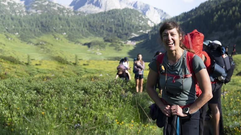 Bergwanderführerin Christina Döderer lachend am Funtensee am zweiten Tag der alpinen Wanderung.