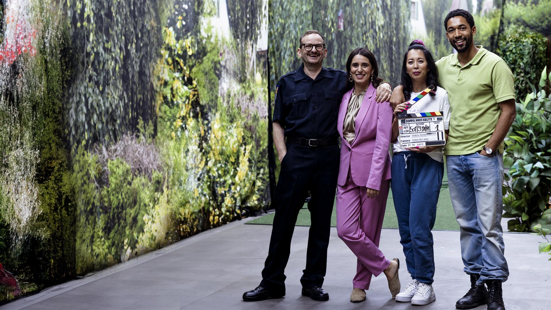Die Schauspielerinnen und Schauspieler der Serie "Doppelhaushälfte" stehen nebeneinander in Studiodekoration. eine Person hält eine Filmklappe in der Hand: v.l. Milan Peschel als Andi Knuppe, Maryam Zaree als Mari Sawadi, Minh-Khai Phan-Thi als Tracy Knuppe, Benito Bause als Theo Kröger.