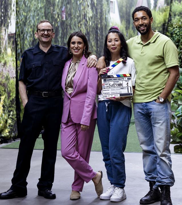 Die Schauspielerinnen und Schauspieler der Serie "Doppelhaushälfte" stehen nebeneinander in Studiodekoration. eine Person hält eine Filmklappe in der Hand: v.l. Milan Peschel als Andi Knuppe, Maryam Zaree als Mari Sawadi, Minh-Khai Phan-Thi als Tracy Knuppe, Benito Bause als Theo Kröger.