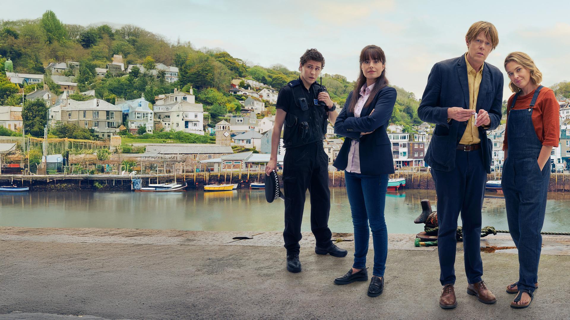 "Beyond Paradise":  Kelby (Dylan Llewellyn), Esther (Zara Ahmadi), Humphrey (Kris Marshall) und Martha (Sally Bretton) stehen vor einem Fluss. Im Hintergrund sind Boote und Häuser zu sehen.