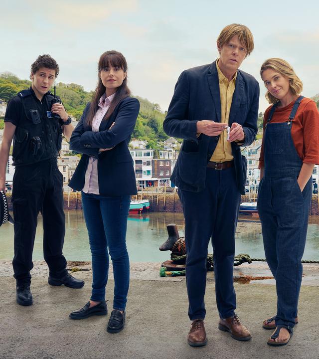 "Beyond Paradise":  Kelby (Dylan Llewellyn), Esther (Zara Ahmadi), Humphrey (Kris Marshall) und Martha (Sally Bretton) stehen vor einem Fluss. Im Hintergrund sind Boote und Häuser zu sehen.