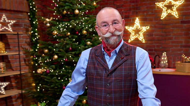 "Der "Bares für Rares"-Weihnachtsabend - Horst Lichter steht im weihnachtlich geschmückten Händlerraum und lächelt in die Kamera.