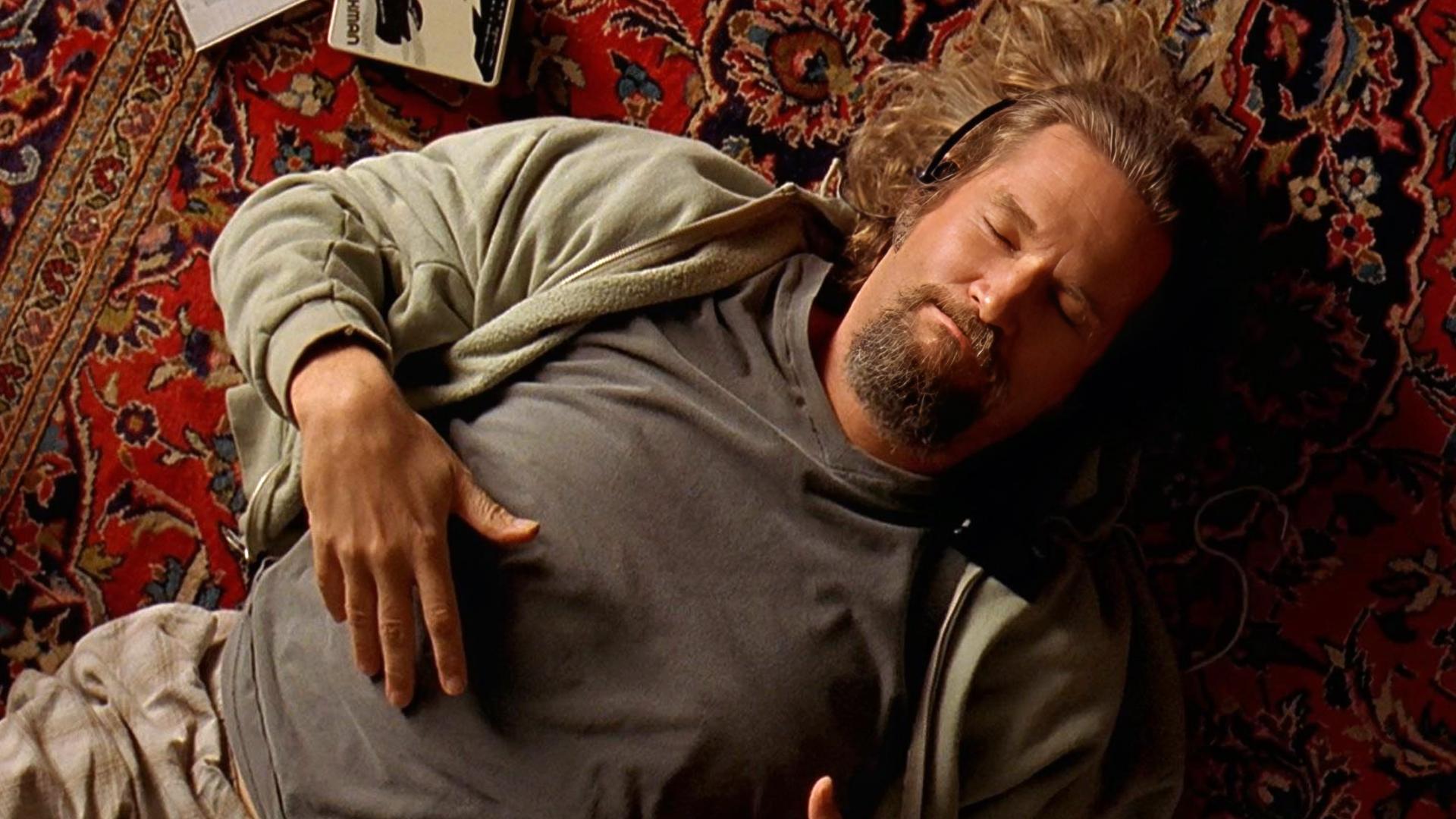 Jeff Bridges liegt auf einem Teppich und raucht