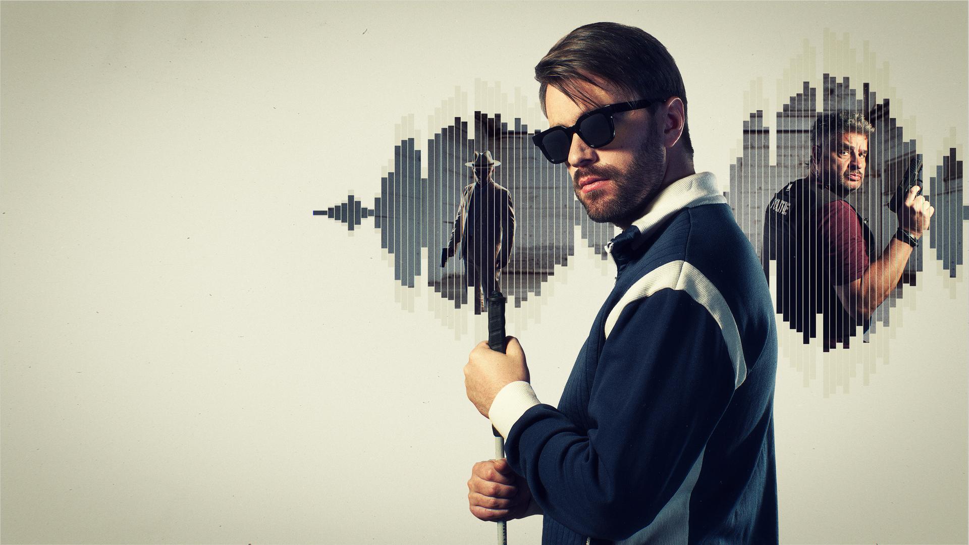 Der blinde Roman Mertens (Bart Kelchtermans) schaut mit dunkler Sonnenbrille in die Kamera. Er hält mit beiden Händen einen Blindenstock vor seiner Brust. Im Hintergrund sieht man innerhalb eines Audio-Diagramms einen Gauner und einen Polizisten. Beide haben eine Pistole in der Hand. 