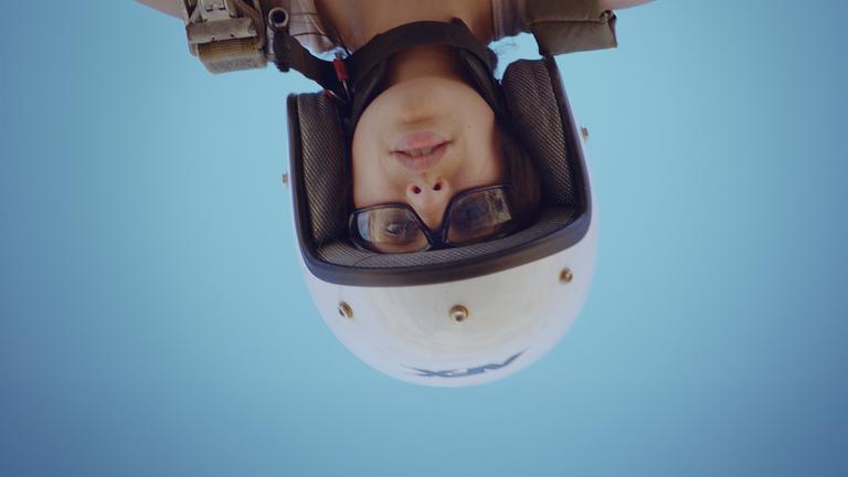 "Born in Evin": Regisseurin und Schauspielerin Maryam Zaree mit Schutzhelm und Schutzbrille bekleidet kopfüber in einem Fallschirm-Geschirr.