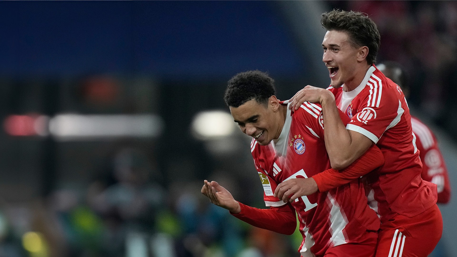 Jamal Musiala vom FC Bayern (links) feiert mit seinem Teamkollegen Tom Bischof, nachdem er im Bundesligaspiel zwischen dem FC Bayern München und Borussia Mönchengladbach in München vom Elfmeterpunkt aus das dritte Tor seiner Mannschaft erzielt hat.