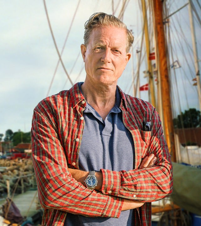Dan Sommerdahl steht mit verschränkten Armen am ufer und schaut ernst nach vorne.