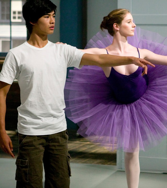 Christian und Tara tanzen während eines Balletttrainings, er im weißen T-Shirt, sie im lilafarbenen Tütü.