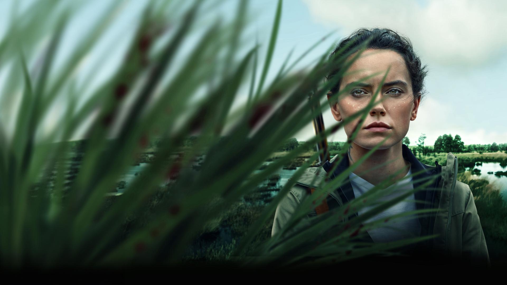 Plakatmotiv: Helena (Daisy Ridley) steht teilweise von Schilf verdeckt vor einem Sumpfgebiet und blauem Himmel mit Wolken. Sie trägt ein Gewehr über ihrer Schulter.
