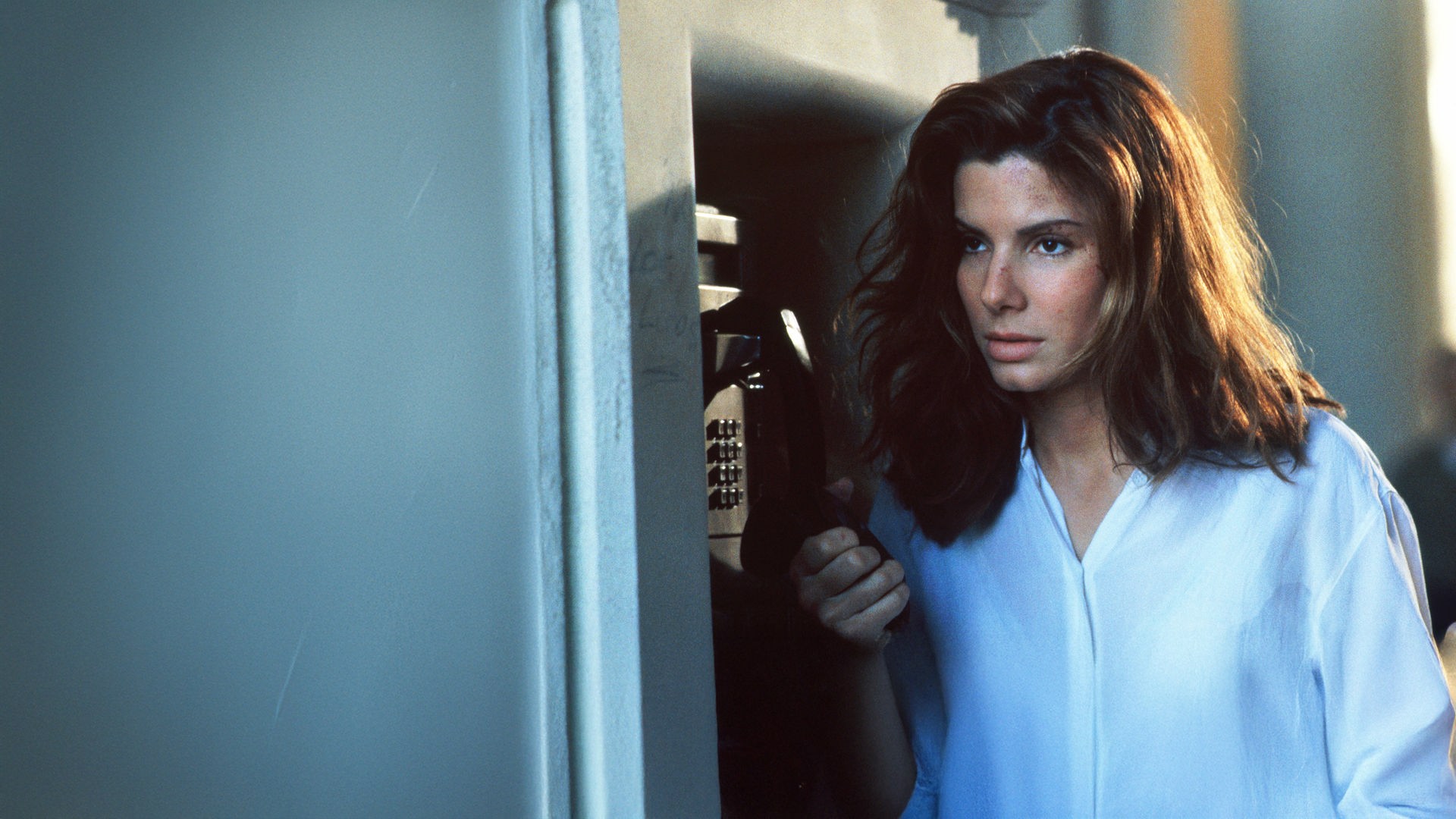 Angela Bennett (Sandra Bullock) ist auf der Flucht. Ratlos steht sie an einem öffentlichen Fernsprecher und hält desillusioniert den Hörer in der Hand. 