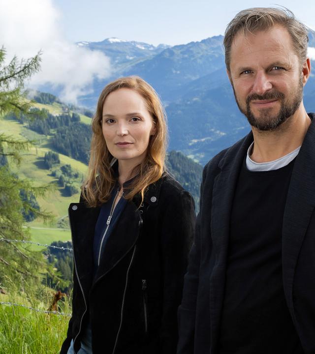 "Der Geier": Franziska Conte (Julia Koch), Lukas Geier (Philipp Hochmair) stehen vor einer Bergkulisse und schauen in die Kamera.
