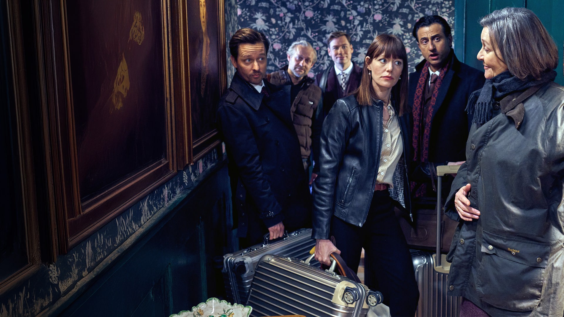 Lady McIntosh (Victoria Carling) führt die Gruppe, bestehend aus Linda (Lavinia Wilson), Bernhard (Serkan Kaya), David (David Kross), Jim (Jürgen Vogel) und Andreas (Tom Schilling), mit einer einladenden Handbewegung und einem Lächeln auf den Lippen durch eine große, alte Holztür in ihr Zimmer. Die Gruppe betritt mit Koffern und skeptischen Blicken den Raum.