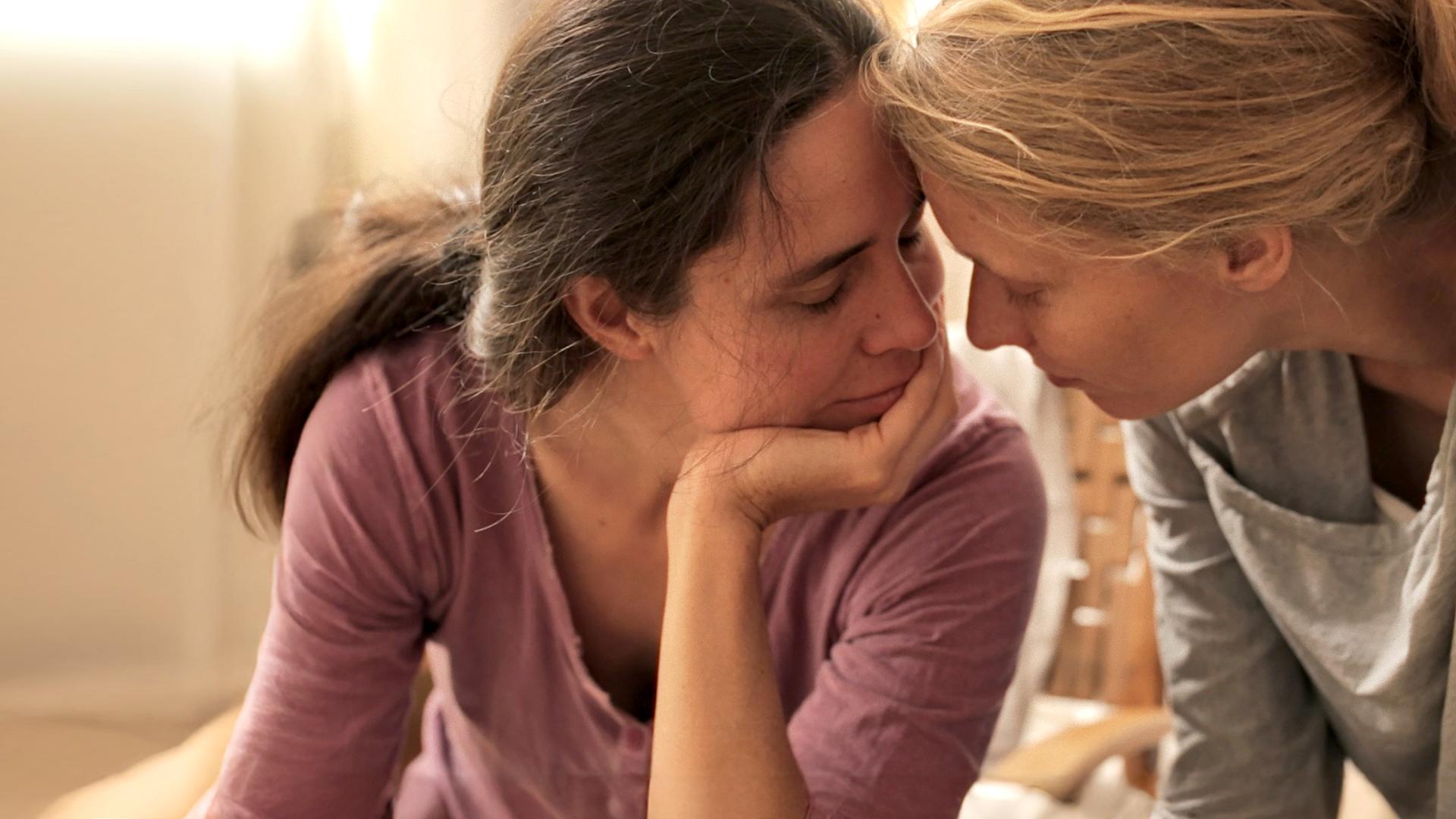 Maria (l.) und Christiane (r.) verbinden sich zärtlich miteinander nach einer Enttäuschung.