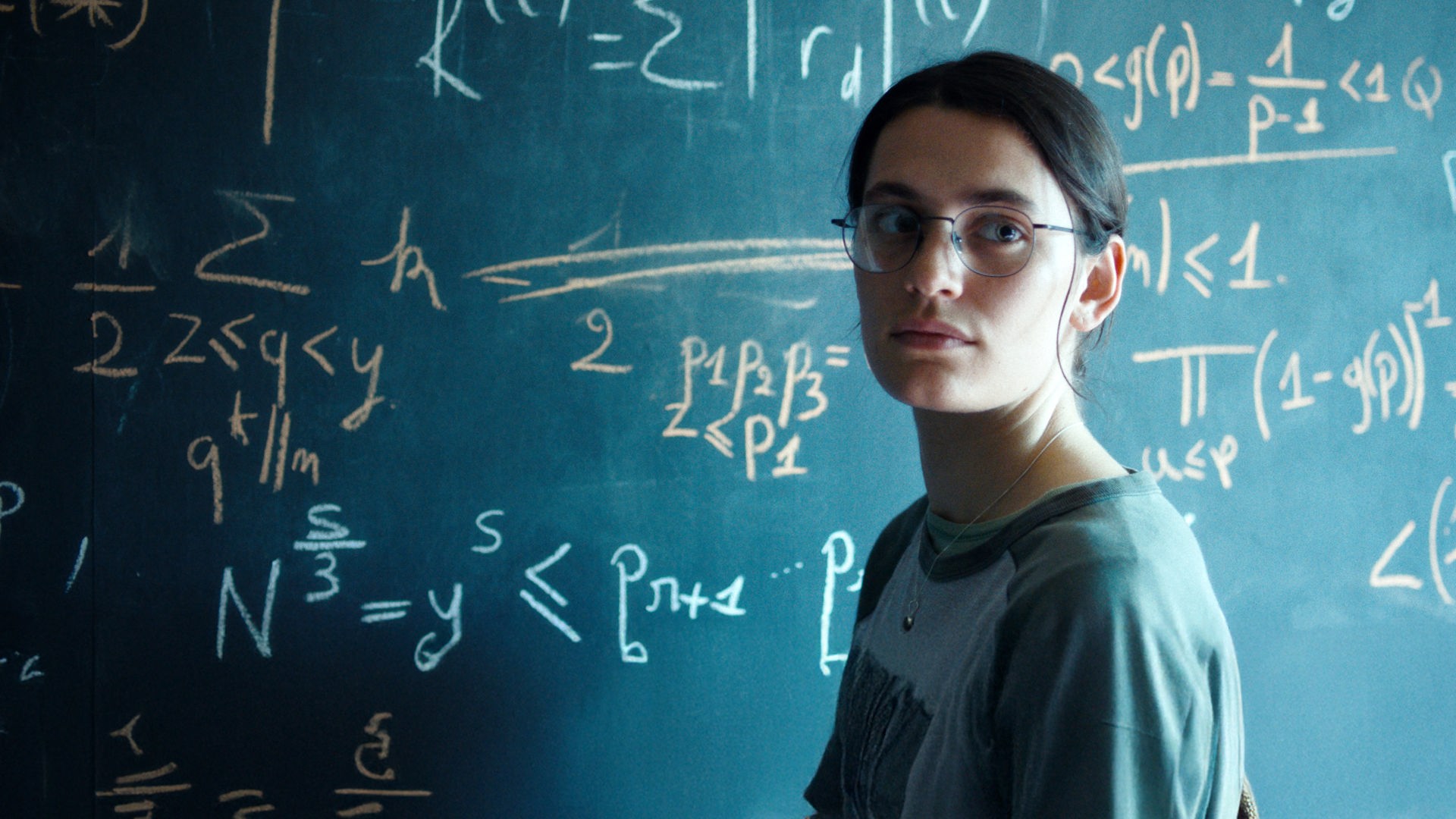 Die Pariser Doktorandin Marguerite (Ella Rumpf) lebt für die Mathematik. "Die Gleichung ihres Lebens": Nahaufnahme: Marguerite (Ella Rumpf) steht neben einer Tafel voll mathematischer Formeln und blickt auf etwas hinter der Kamera.