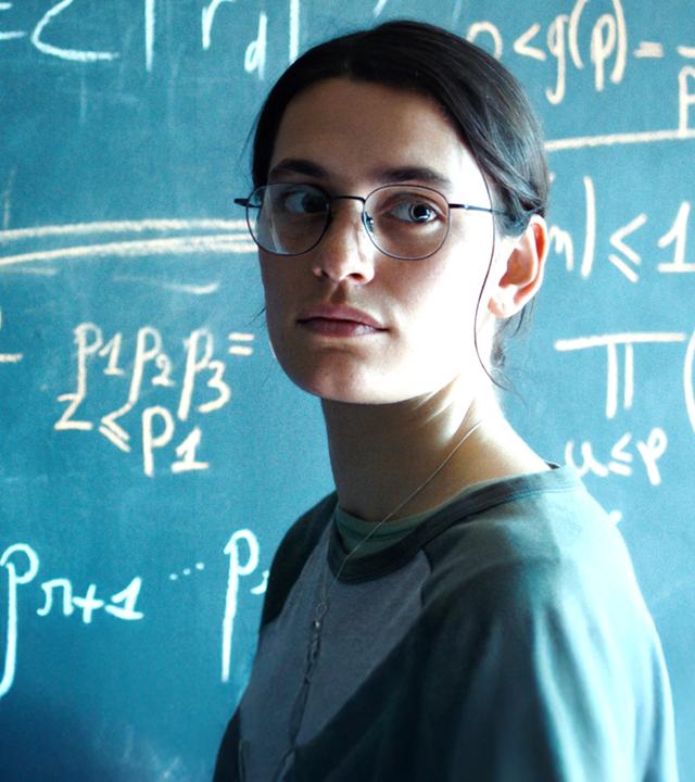 Die Pariser Doktorandin Marguerite (Ella Rumpf) lebt für die Mathematik. "Die Gleichung ihres Lebens": Nahaufnahme: Marguerite (Ella Rumpf) steht neben einer Tafel voll mathematischer Formeln und blickt auf etwas hinter der Kamera.