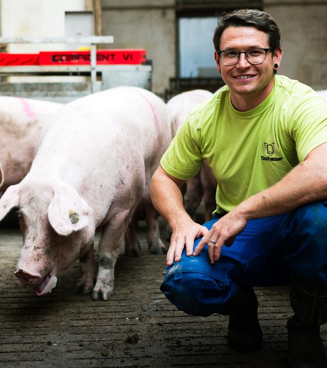 Simon Donhauser mit einem Ferkel in der Hand.