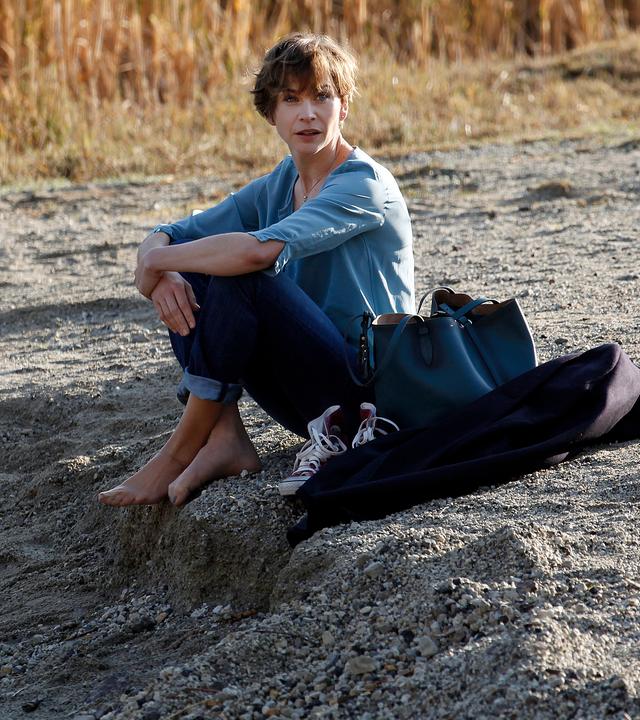 Vicky (Christiane Paul) sitzt am Ufer eines Sees.