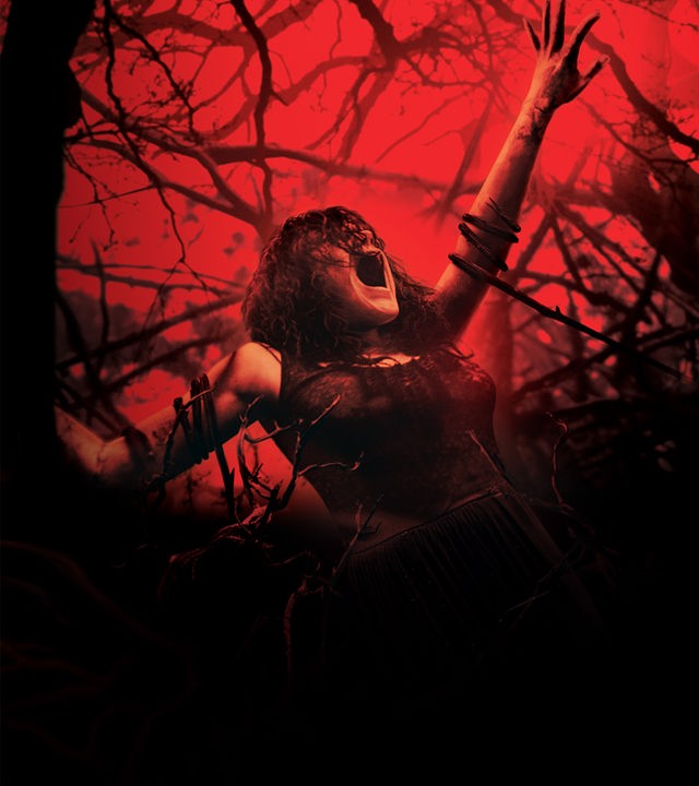 Plakatmotiv zum Film mit Jane Levy. In einem bedrohlich rot beleuchteten Wald reckt Mia ängstlich und qualvoll den Arm nach oben, während sie versucht, sich aus Ästen und Ranken zu befreien, die sie an den Armen und Beinen fesseln.