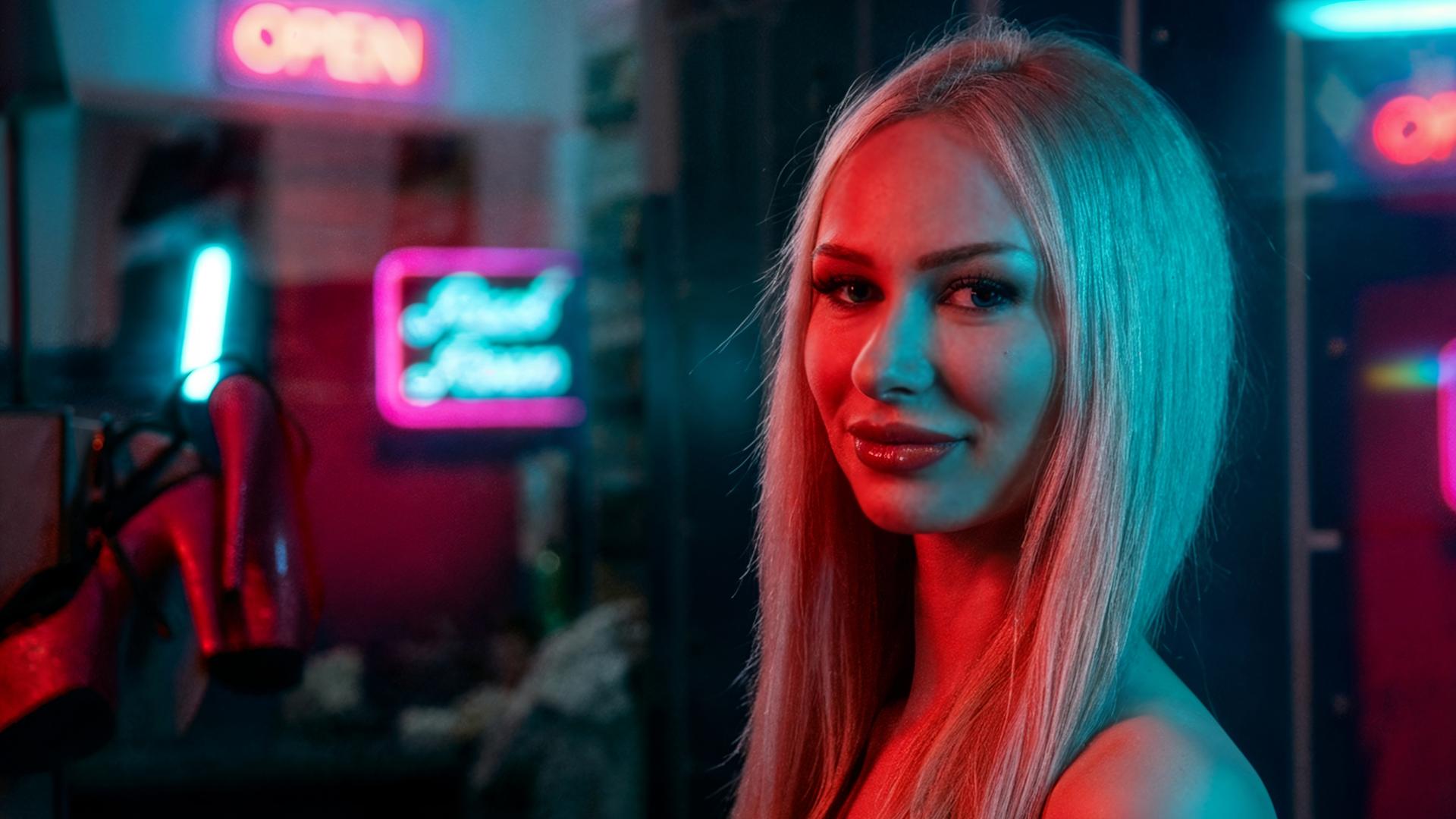 Stripperin Anabelle, 19, tanzt an der Stange des Nachtclubs "Pure Platinum". Die junge Frau mit blonden langen Haaren schaut seitlich in die Kamera. Die Lichteffekte im Hintergrund wurden mit KI bearbeitet.  