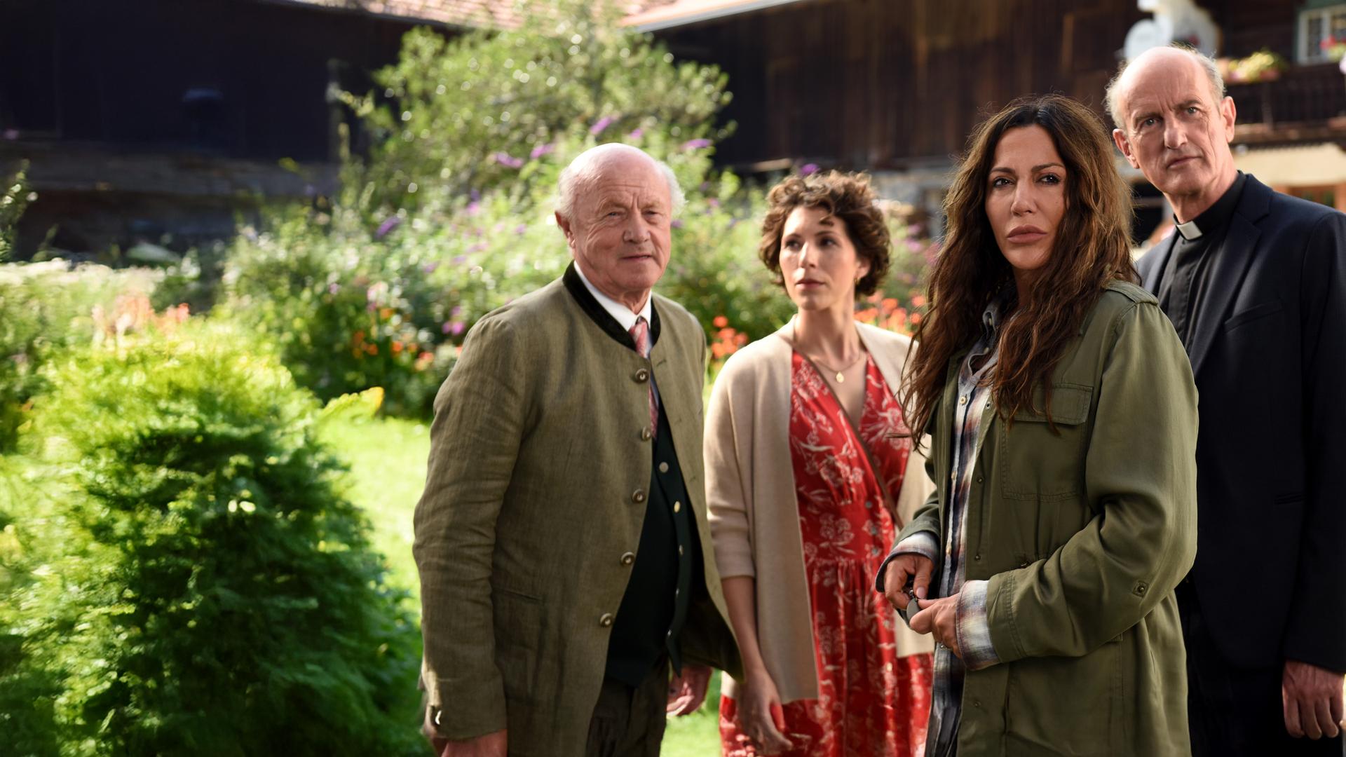 Alois Frankenthal (Hans Stadlbauer), Tatjana Feichtkamm (Eva-Maria Reichert), Katja Baumann (Simone Thomalla) und Pfarrer Sonnleitner (Johannes Herrschmann) stehen vor einem Bauernhaus.