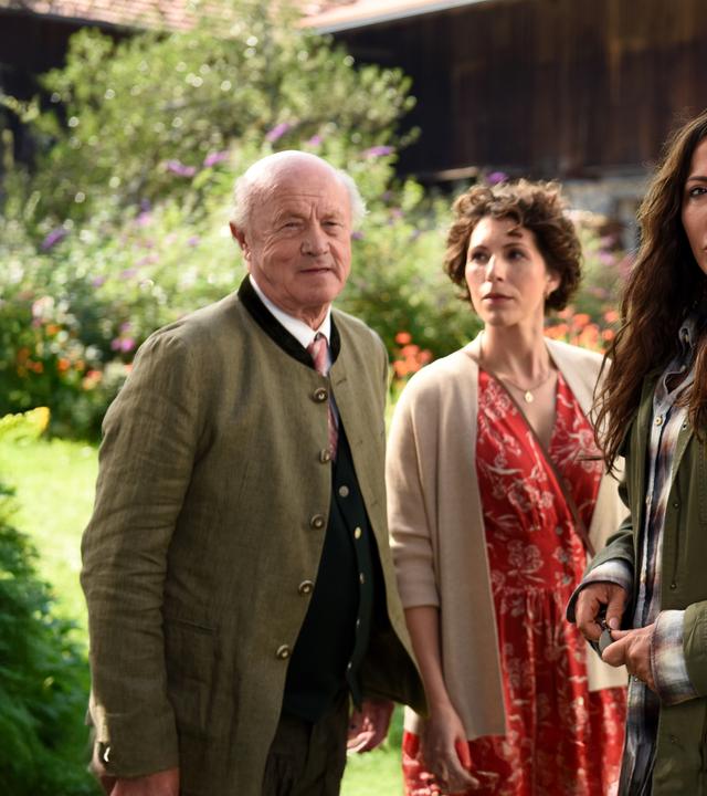 Alois Frankenthal (Hans Stadlbauer), Tatjana Feichtkamm (Eva-Maria Reichert), Katja Baumann (Simone Thomalla) und Pfarrer Sonnleitner (Johannes Herrschmann) stehen vor einem Bauernhaus.