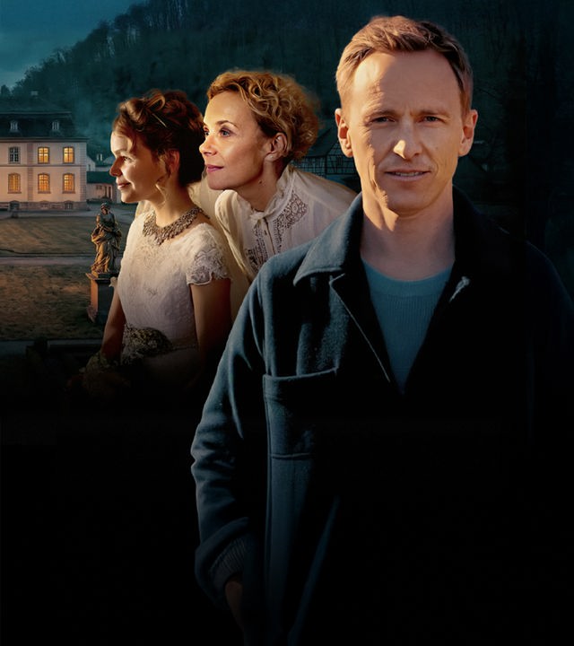Jochen Breyer im Vordergrund, Schauspielerin Katja Riemann als Hausdame und eine Braut (Statistin), im Hintergrund Schloss Ebnet."