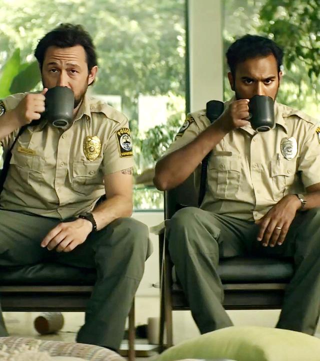 Terry (Joseph Gordon-Levitt) und Will (Himesh Patel) sitzen in Polizeiuniform nebeneinander vor einer Fensterfront mit Blick ins Grüne.