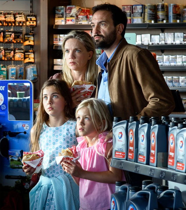  Ed (Willem de Wolf) ist nur von der Rückseite zu sehen und hat beide Hände in der Hosentasche versteckt. Robine (Liz Vergeer) und Milou (Roosmarijn van der Hoek) halten beide ein Sandwich in der Hand und blicken in leicht gebeugter Haltung verängstigt in Eds Richtung. Hans (Jeroen Spitzenberger), der neben seiner Frau und hinter beiden Töchtern steht, hält seine linke Hand beschützend um Robines linke Schulter. Diana hält ebenfalls ein Brötchen in der Hand und sieht Ed schockiert an.