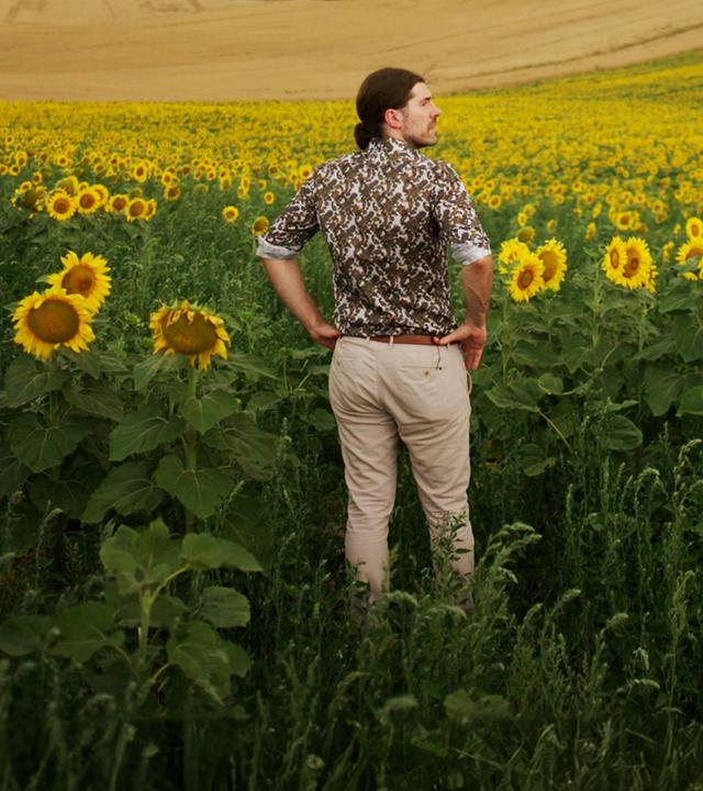  Alexander Prinz steht in einem Sonnenblumenfeld