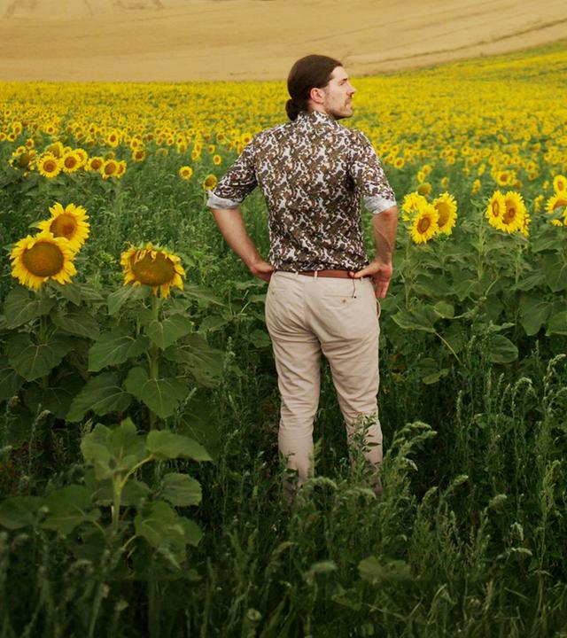  Alexander Prinz steht in einem Sonnenblumenfeld