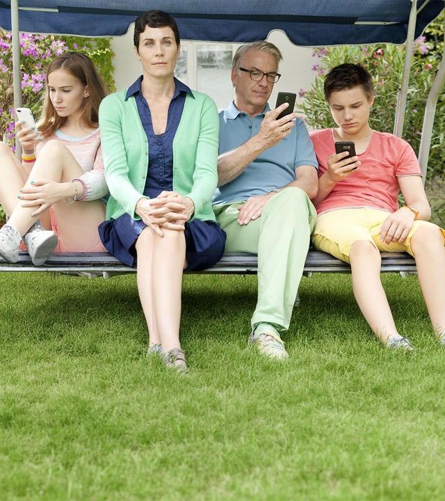 Marie (Tara Fischer), Klaus (Christoph M. Ohrt) und Benny (Ludwig Skuras) sitzen vertieft in ihre Handys in der Hollywoodschaukel. Heike (Nina Kunzendorf) sitzt ohne Smartphone dazwischen.