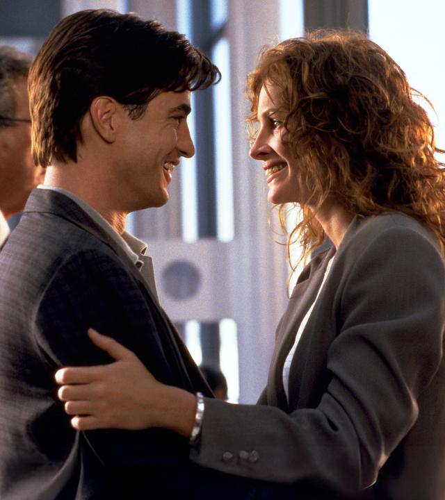 Michael (Dermot Mulroney) und Jules (Julia Roberts) stehen sich gegenüber und begrüßen sich innig
