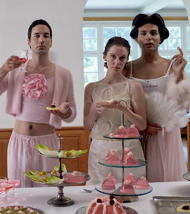 Karlheinz (Thomas Hauser), Romy (Julia Windischbauer), Magda Gustav (Benjamin Radjaipour) unterhalten sich am Frühstücksbuffet