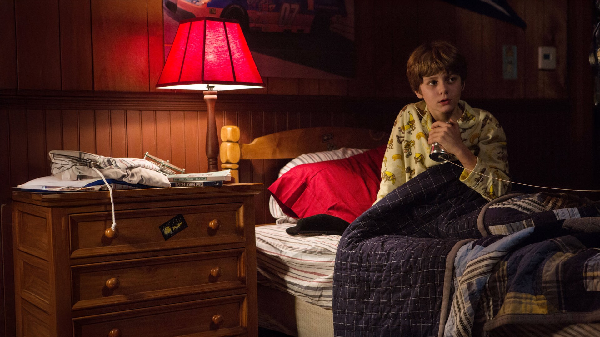 "Insidious: Chapter 2": Dalton (Ty Simpkins) sitzt ängstlich in seinem Bett und umklammert sein selbst gebasteltes Dosentelefon.