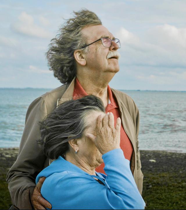 "Jenseits von Schuld": Ulla und Didi Högel stehen nebeneinander mit den Gesichtern dem Wind zugewandt am Strand.